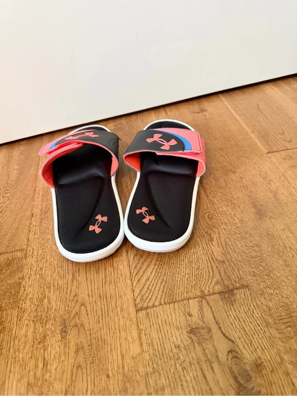 Under Armour Ignite VI coral and black slides with pink and blue accents sandals